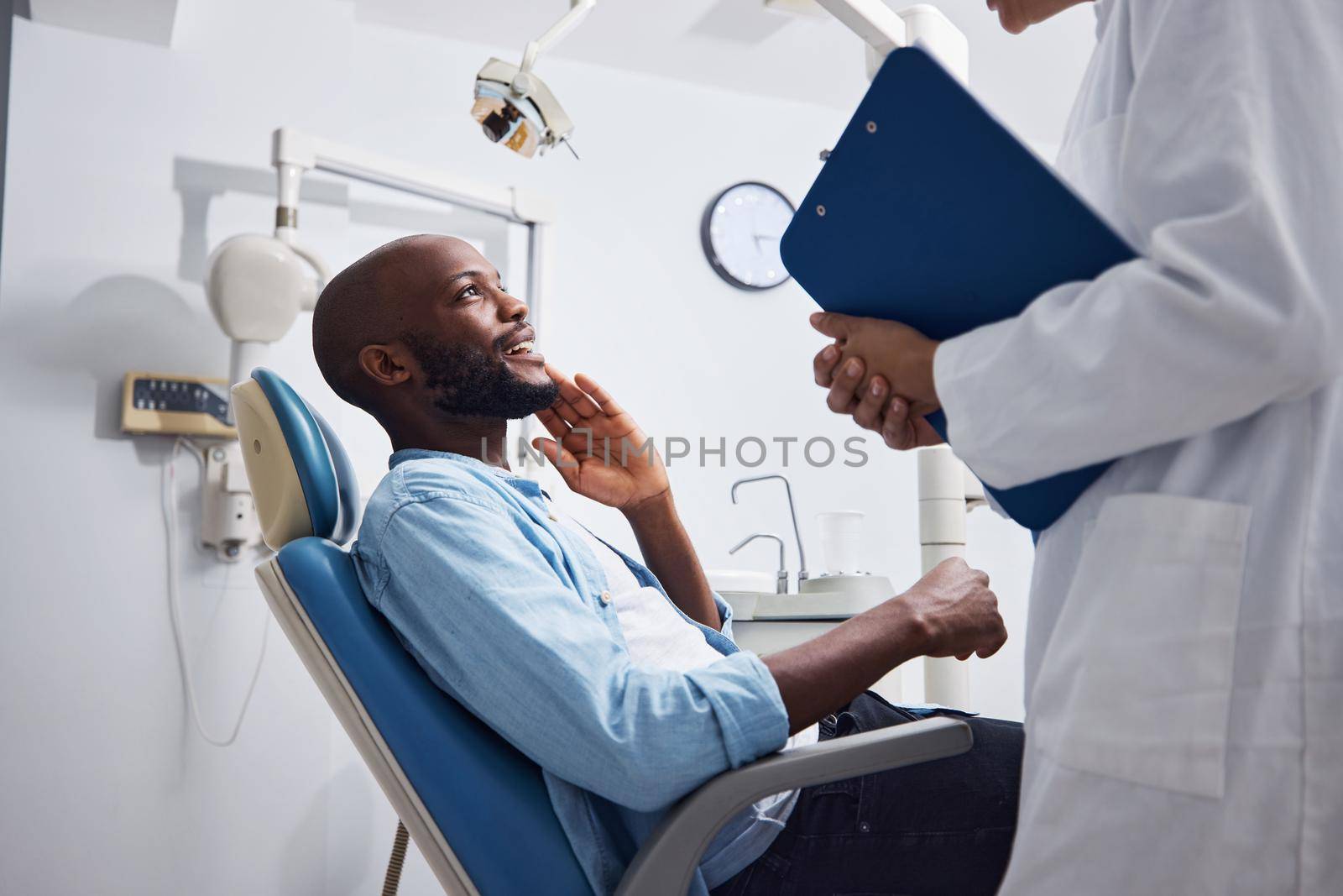 Shot of a young man having a consultation with his dentist.