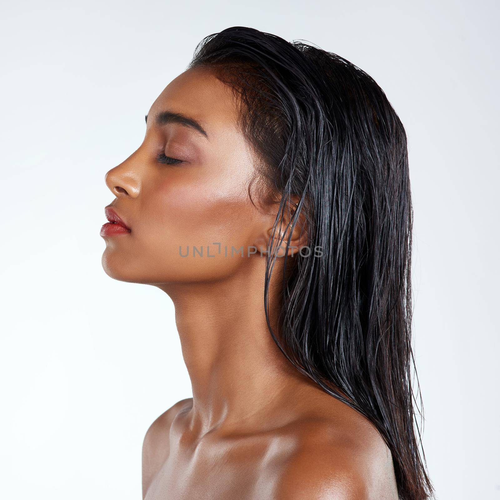 Studio shot of a beautiful young woman posing against a light background.