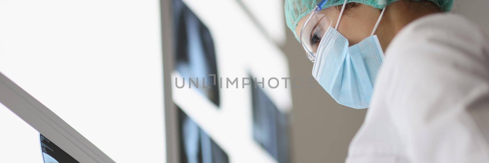 Low angle of medical worker analyzing xray on screen. Nurse in uniform examine patients scan, preparing conclusion and prescription for therapy. Medicine, checkup, laboratory concept