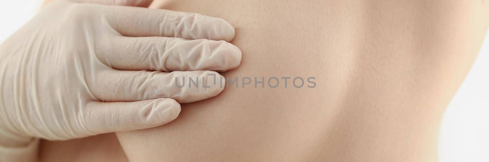 Close-up of woman preparing for breast operation, topless female cover boob with hand in glove. Desire for breast augmentation, surgery made in clinic. Beauty, plastic, cosmetic surgery concept