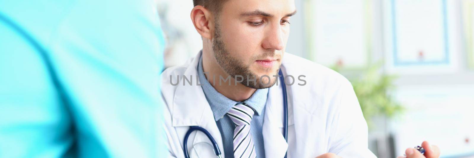 Portrait of male intern correct prescription, consulting with head doctor about treatment for patient. Learn experience from older, get knowledge on practice in clinic. Medicine, healthcare concept