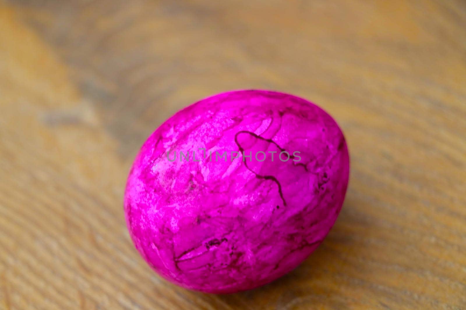 A pink painted egg is on the table. Preparing for Easter