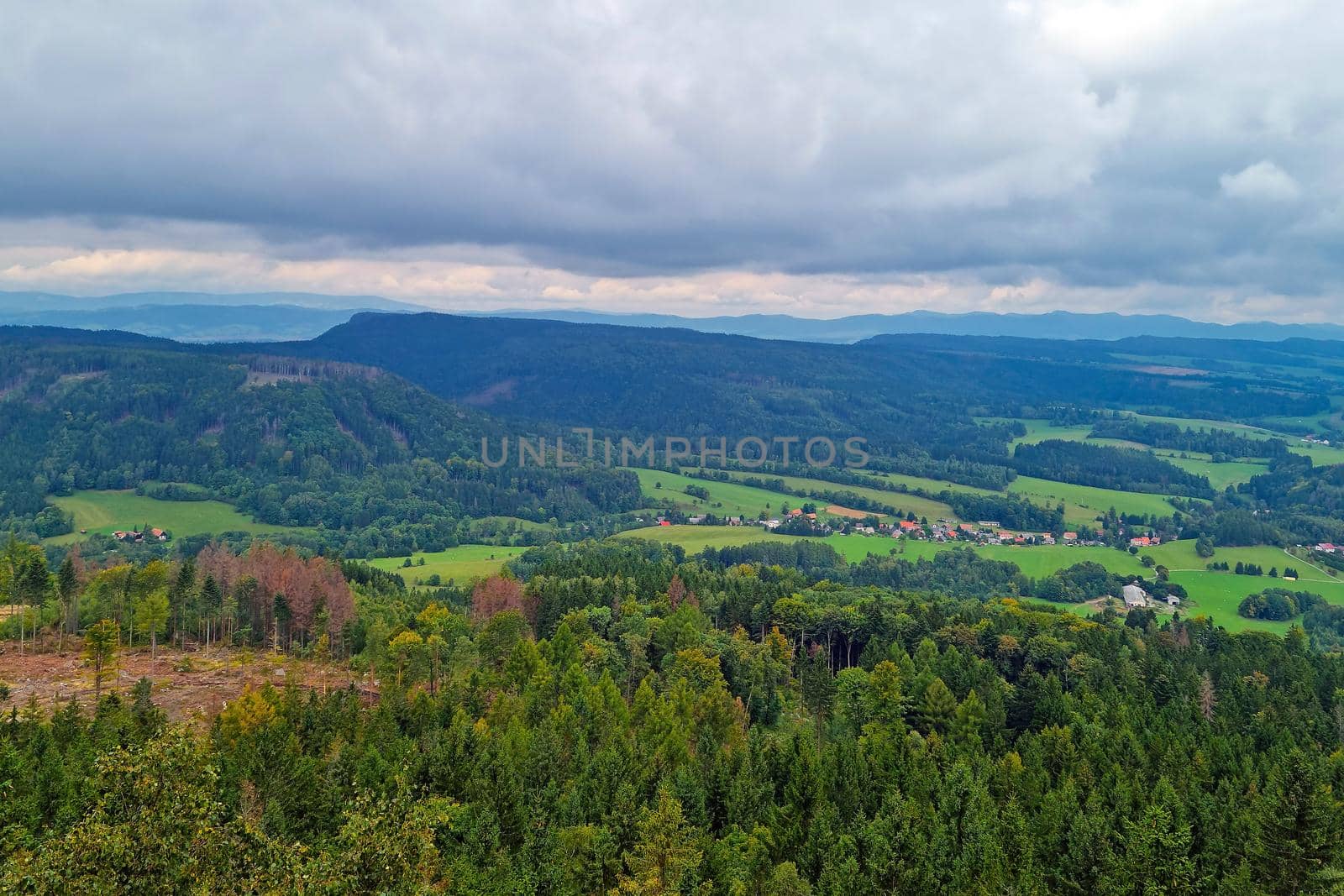 A picturesque view from a height of the green mountains on a foggy overcast morning