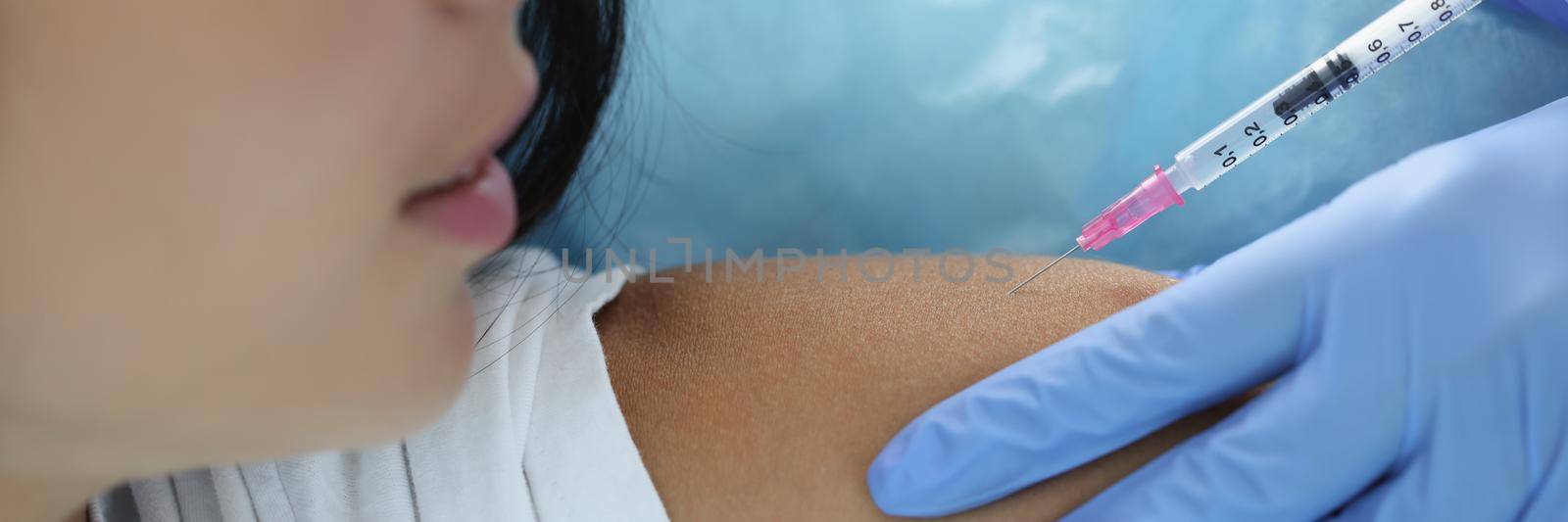 Close-up of doctor hand holding syringe making covid vaccination injection dose in shoulder of female patient, vaccination injection on arm. Coronavirus immunization, medicine, healthcare concept