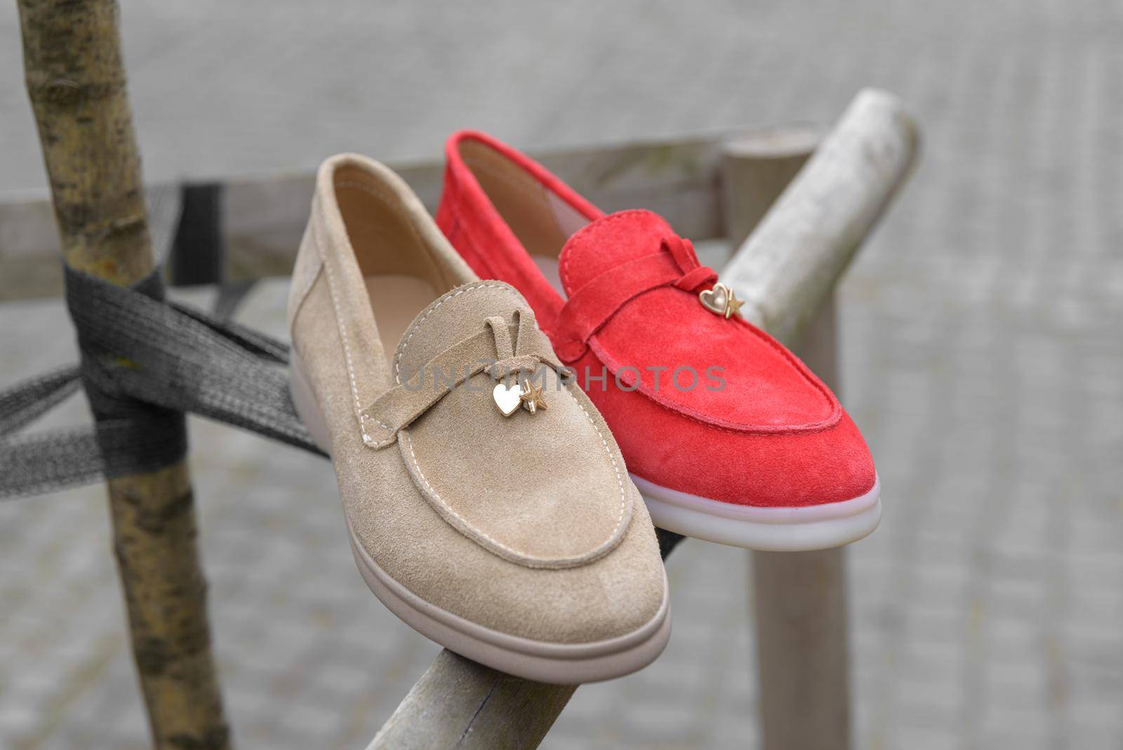 Woman's red and coral stylish suede loafer shoes. Pair of trendy female loafers shoes, outdoors