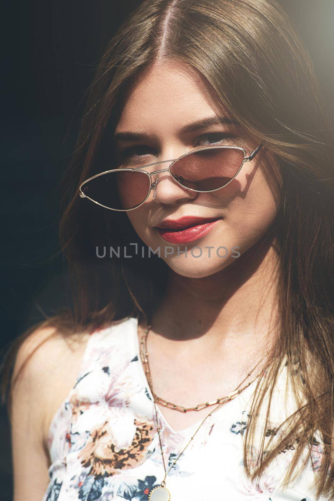 Close up fashion portrait of pretty girl, have long amazing brunette hairs, wearing vintage sunglasses, and bright lipstick.