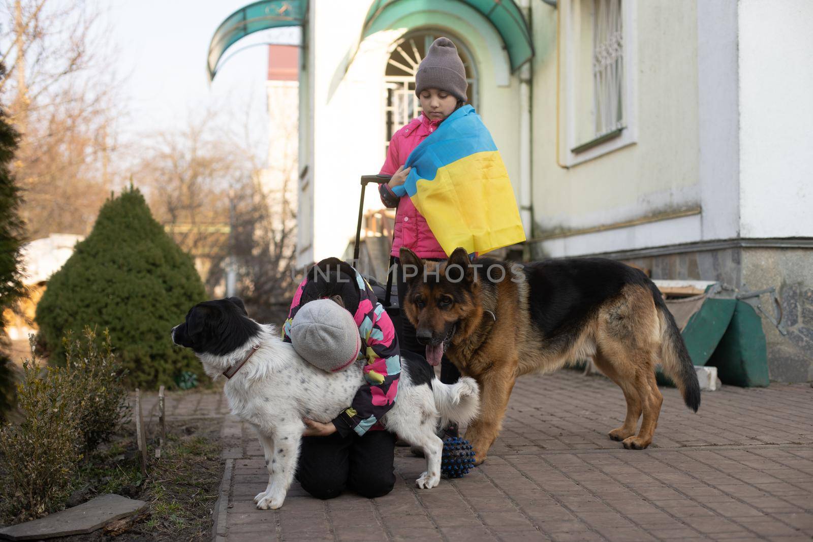 Ukraine military migration. two little girls with a suitcase. Flag of Ukraine, help. Crisis, military conflict.