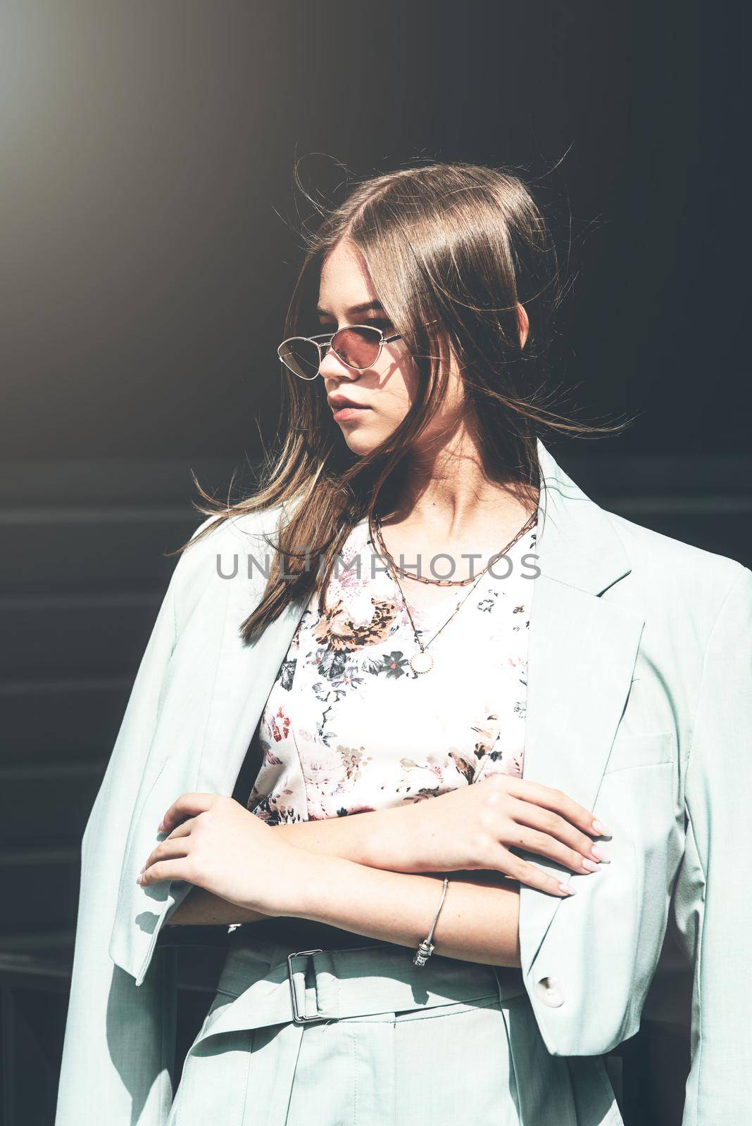 Fashion portrait of young woman wearing sunglasses, top and blue suit. Young beautiful happy model posing on the dark background by Ashtray25