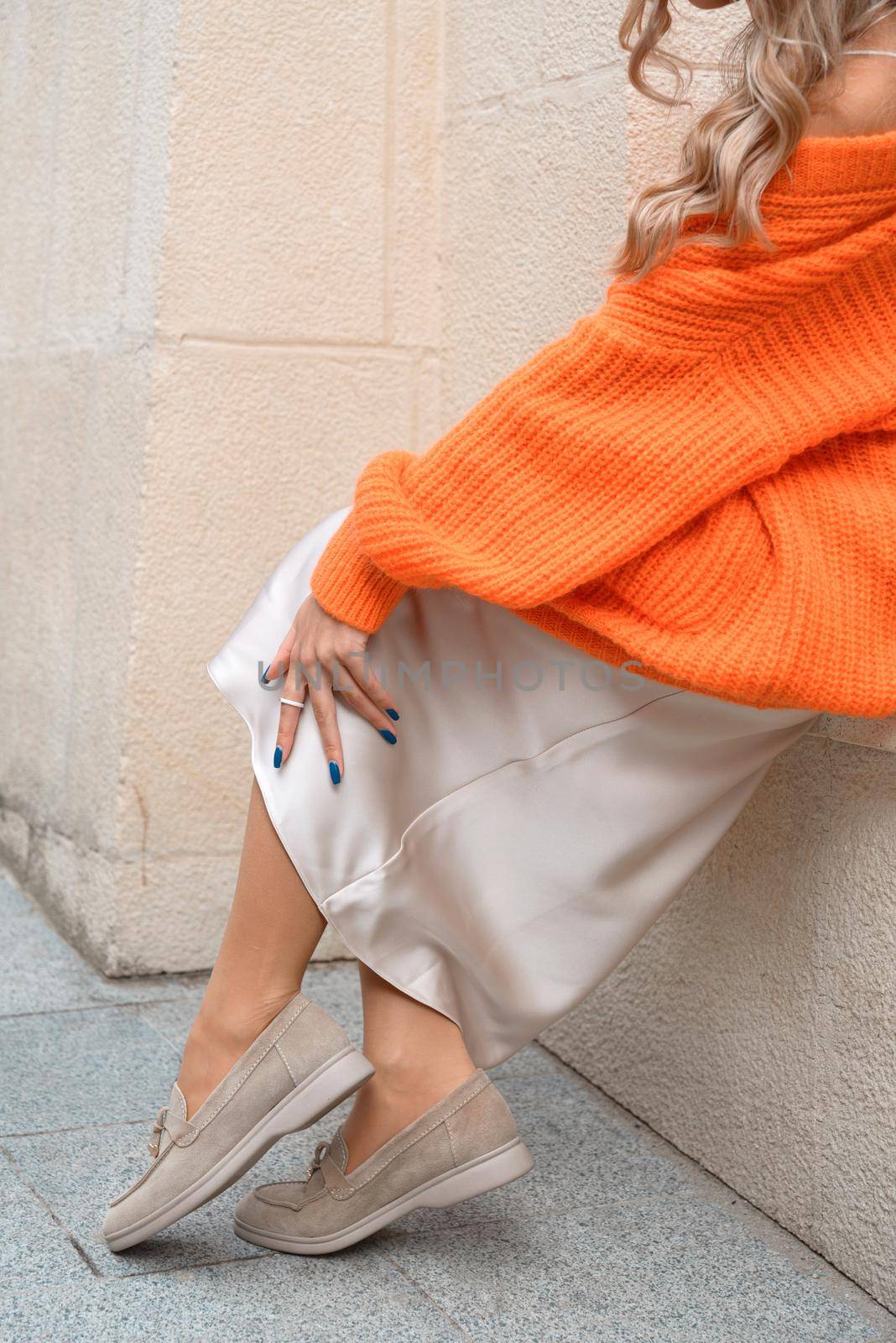 Portrait of fashionable women in orange sweater and beige dress posing in the street by Ashtray25