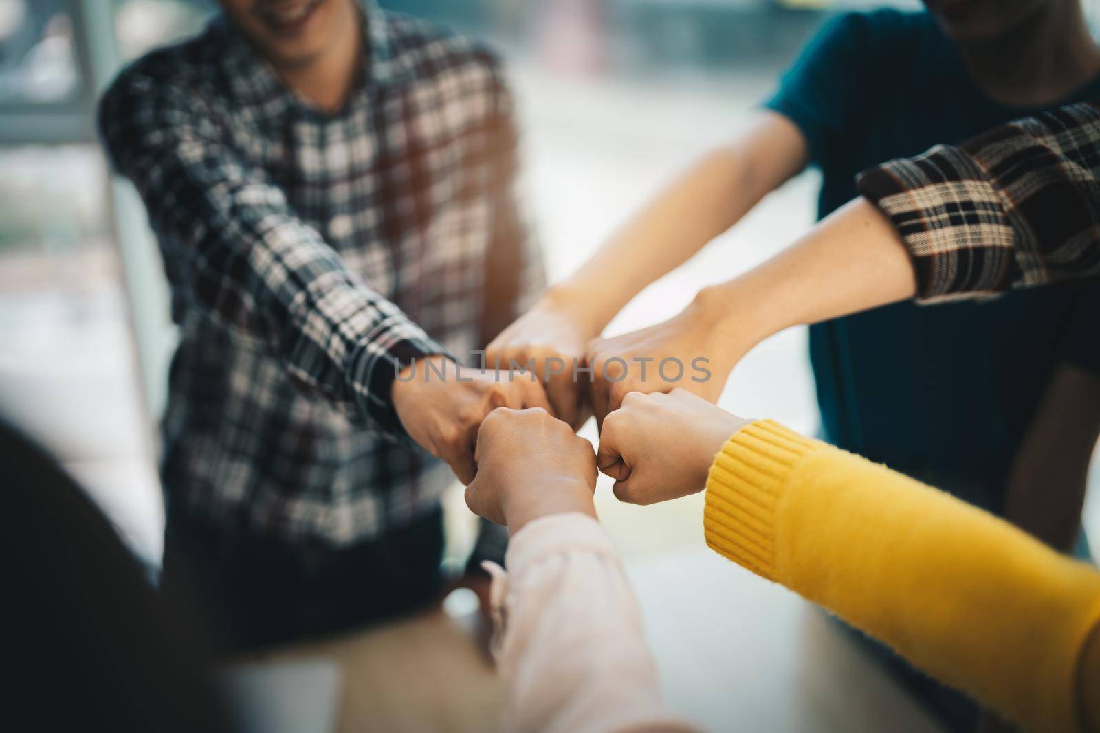 diverse group of asian business partner fist bump in modern office. Colleague partnership teamwork, university student, congratulation event, job or mission accomplish concept.