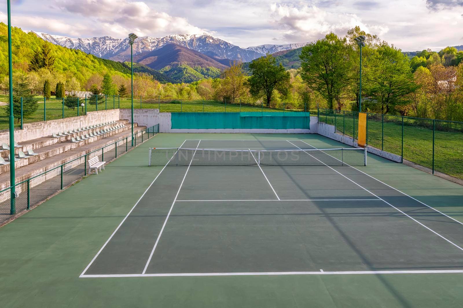 Tennis court. Trees and mountains around the tennis court in nature.