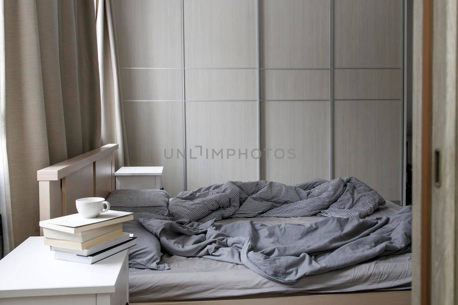 An unmade bed with two duvets in gray duvet covers. Morning concept by elenarostunova