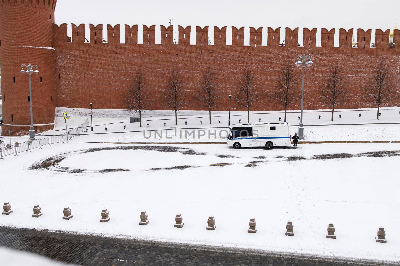 Moscow, Russia - 28 March 2022, A policeman stands near a paddy wagon parked on the deserted Red Square. blizzard