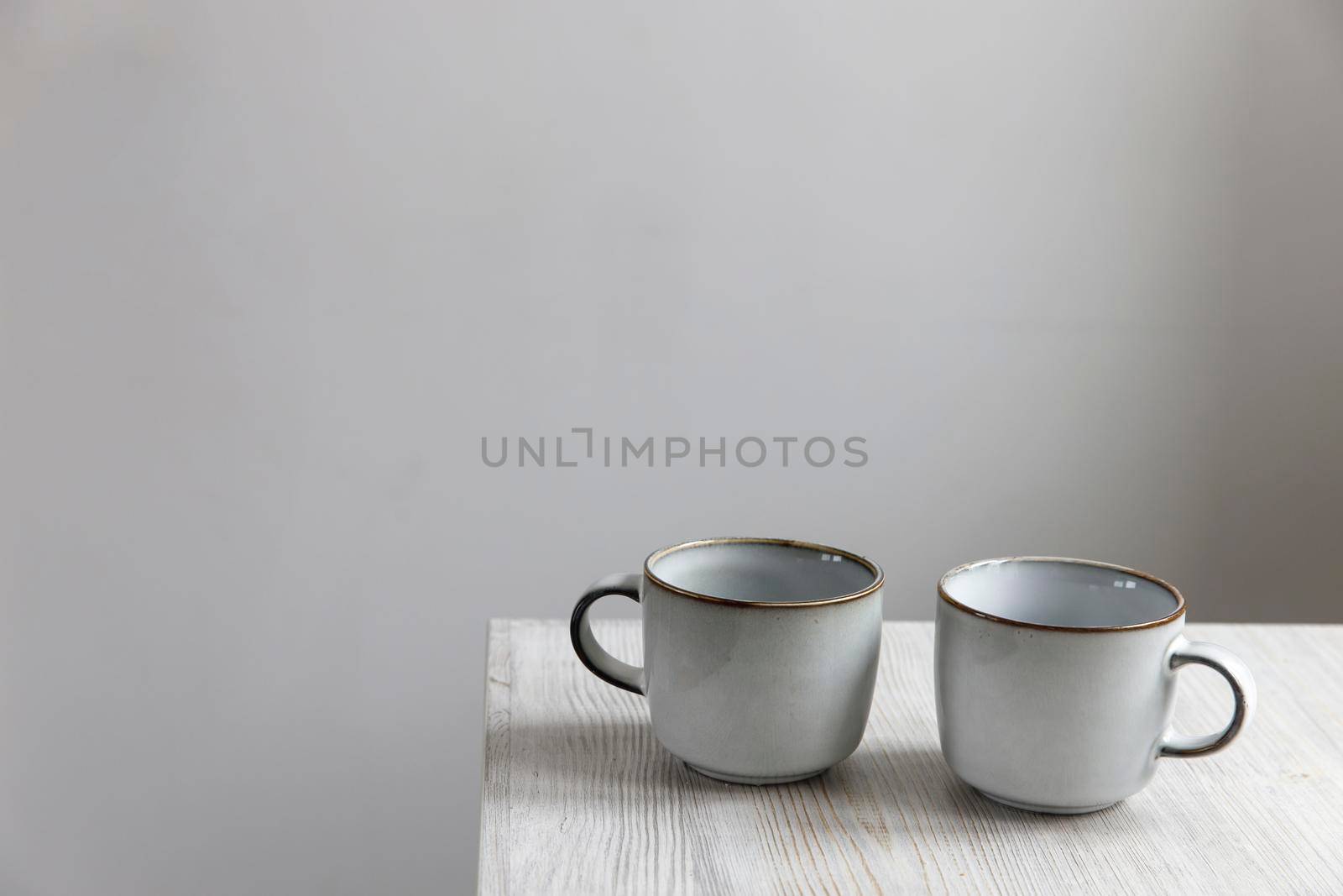 Two porcelain light blue cups are on the table by elenarostunova