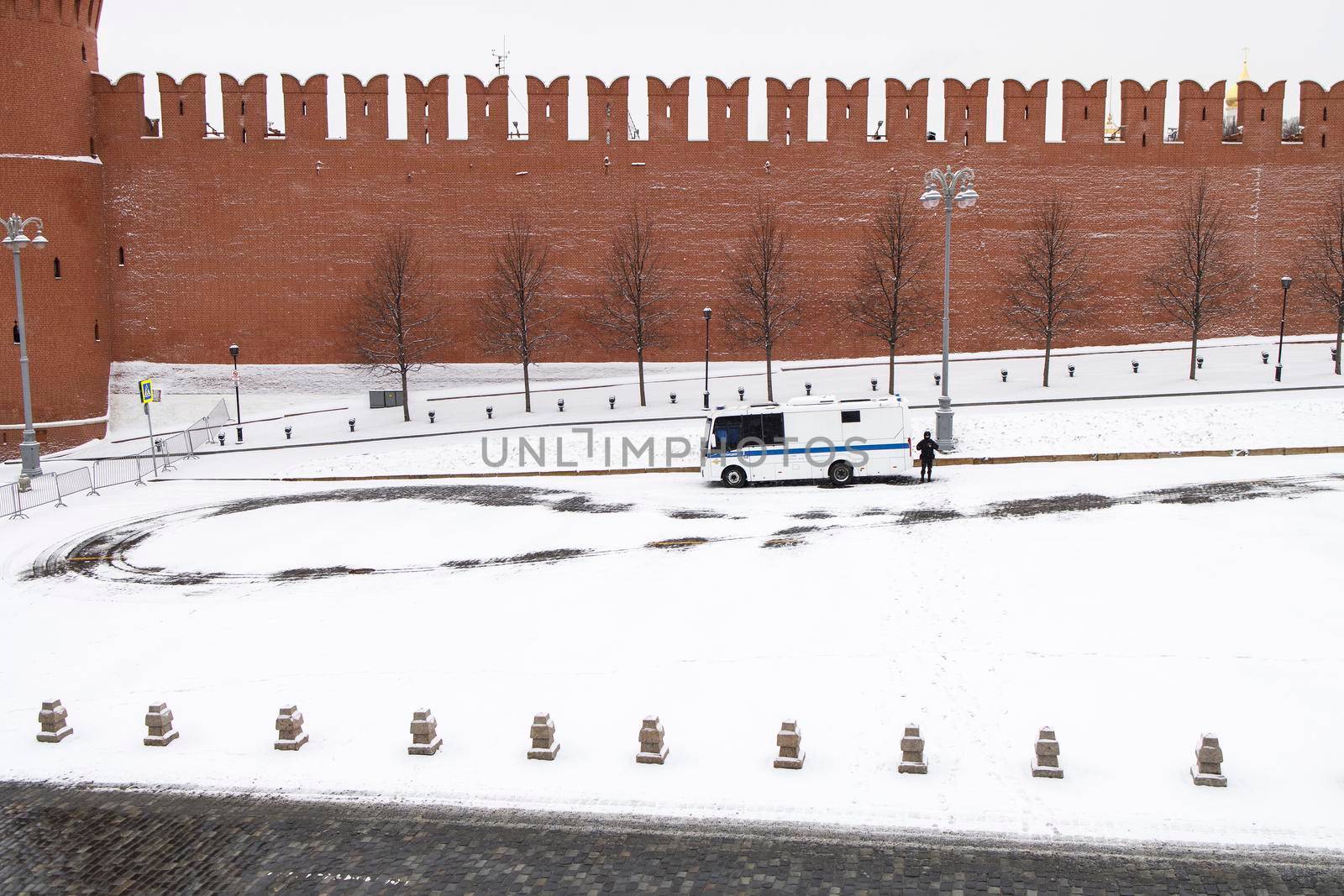 Moscow, Russia - 28 March 2022, A policeman stands near a paddy wagon parked on the deserted Red Square. blizzard