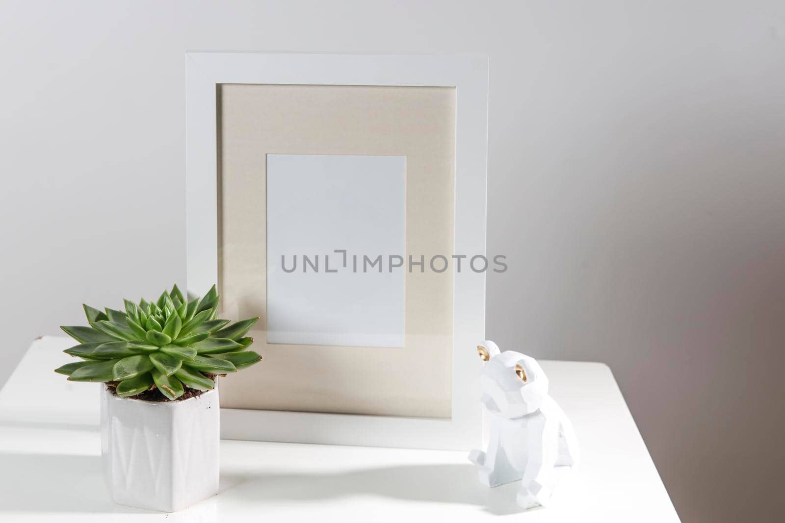 Echeveria in a geometric pot next to a photo frame and a wooden bear figurine. Layout. Place for text. Scandinavian style by elenarostunova