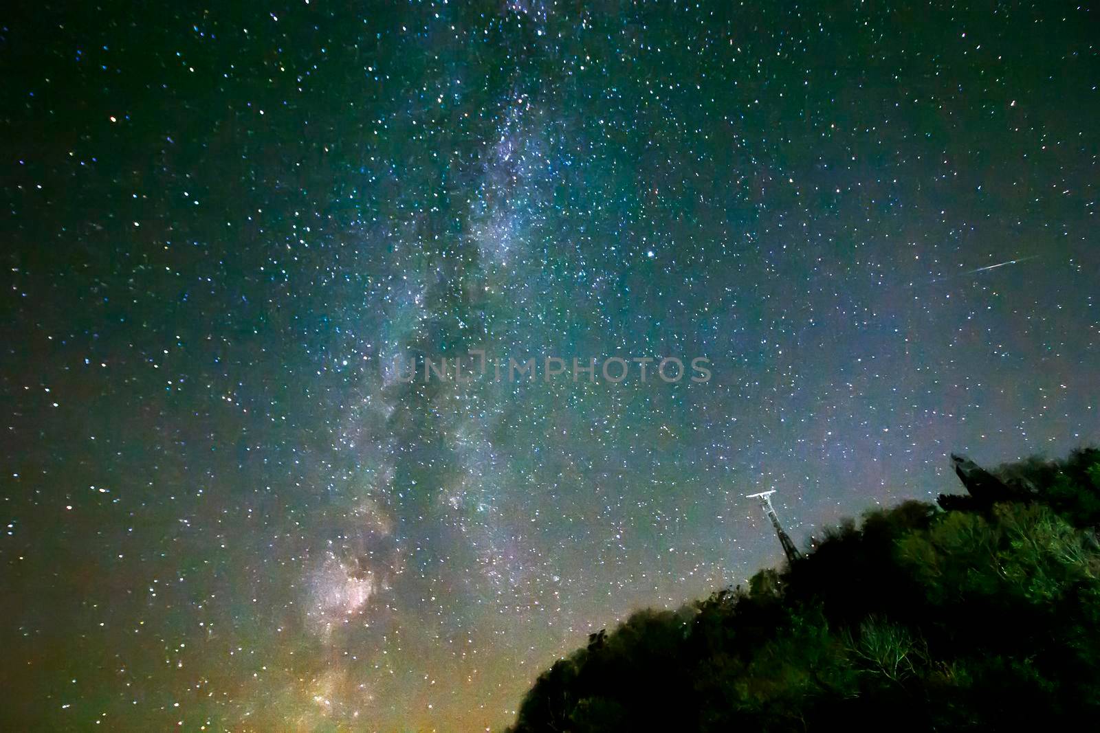 Night sky with stars and milky way over hill