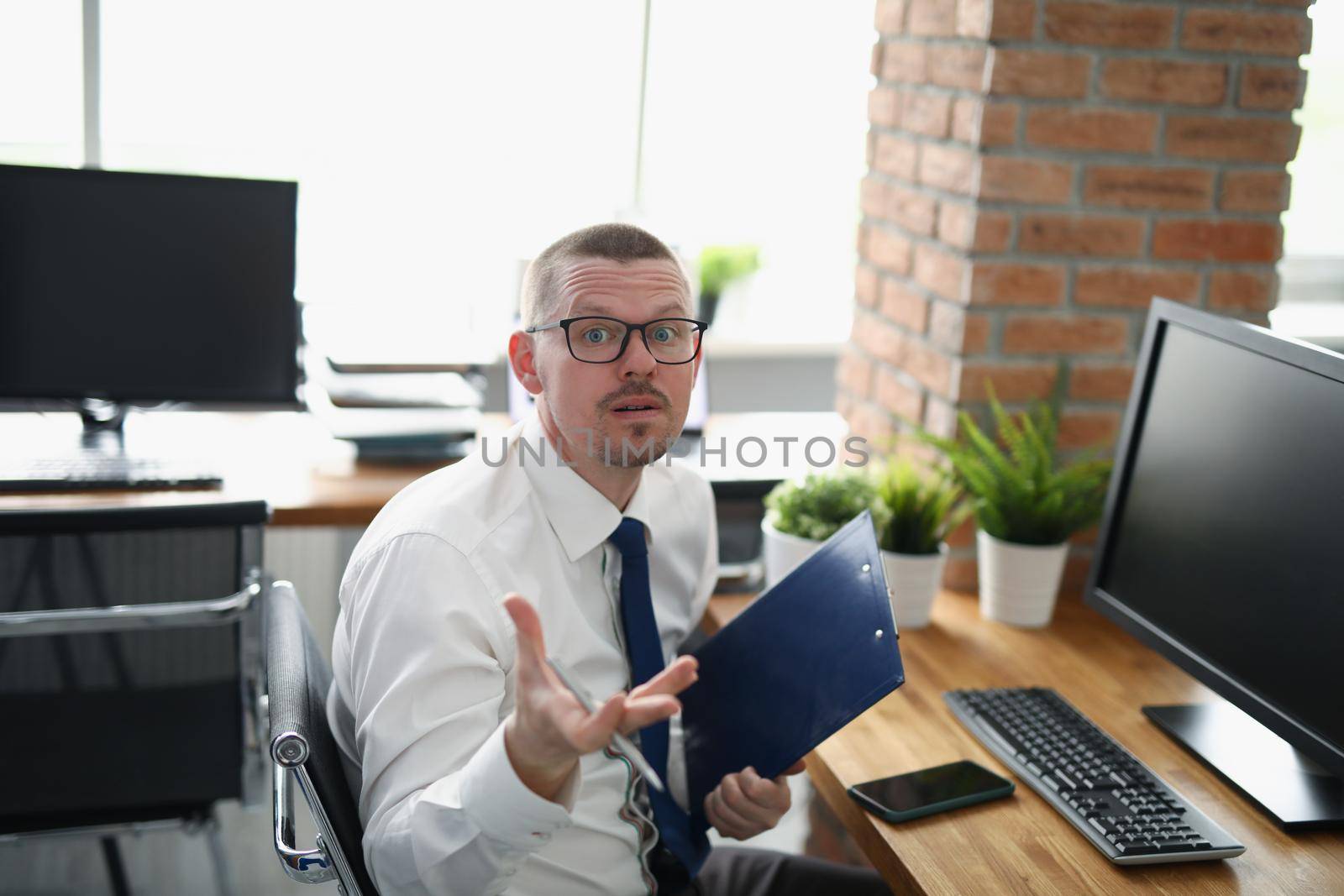 Portrait of employee with mixed emotions, loaded with work, stressed with paperwork. Man in suit on workplace, hard working all day, no break for lunch. Business, job concept