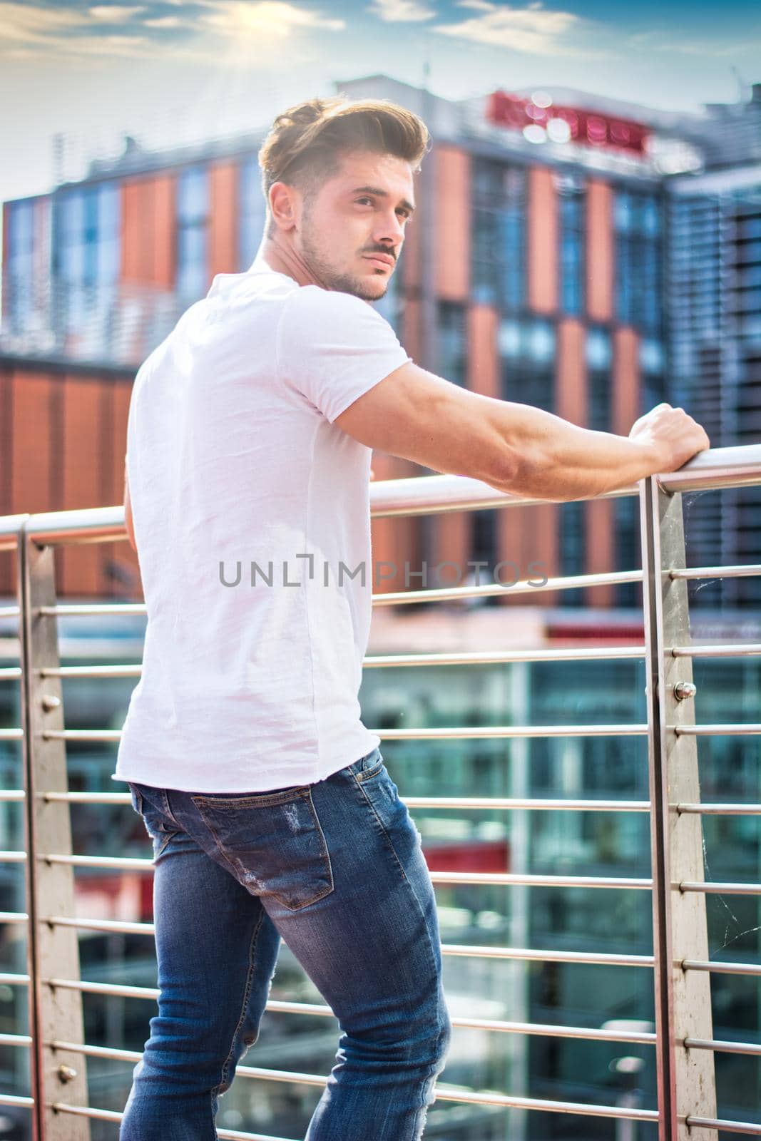 Handsome young man in white t-shirt outdoor in city setting by artofphoto