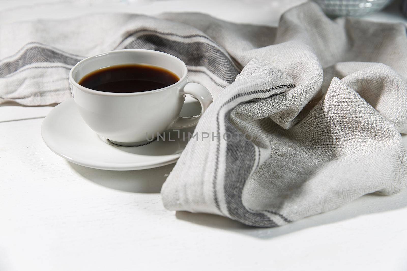 Cup of tea with napkin on white background
