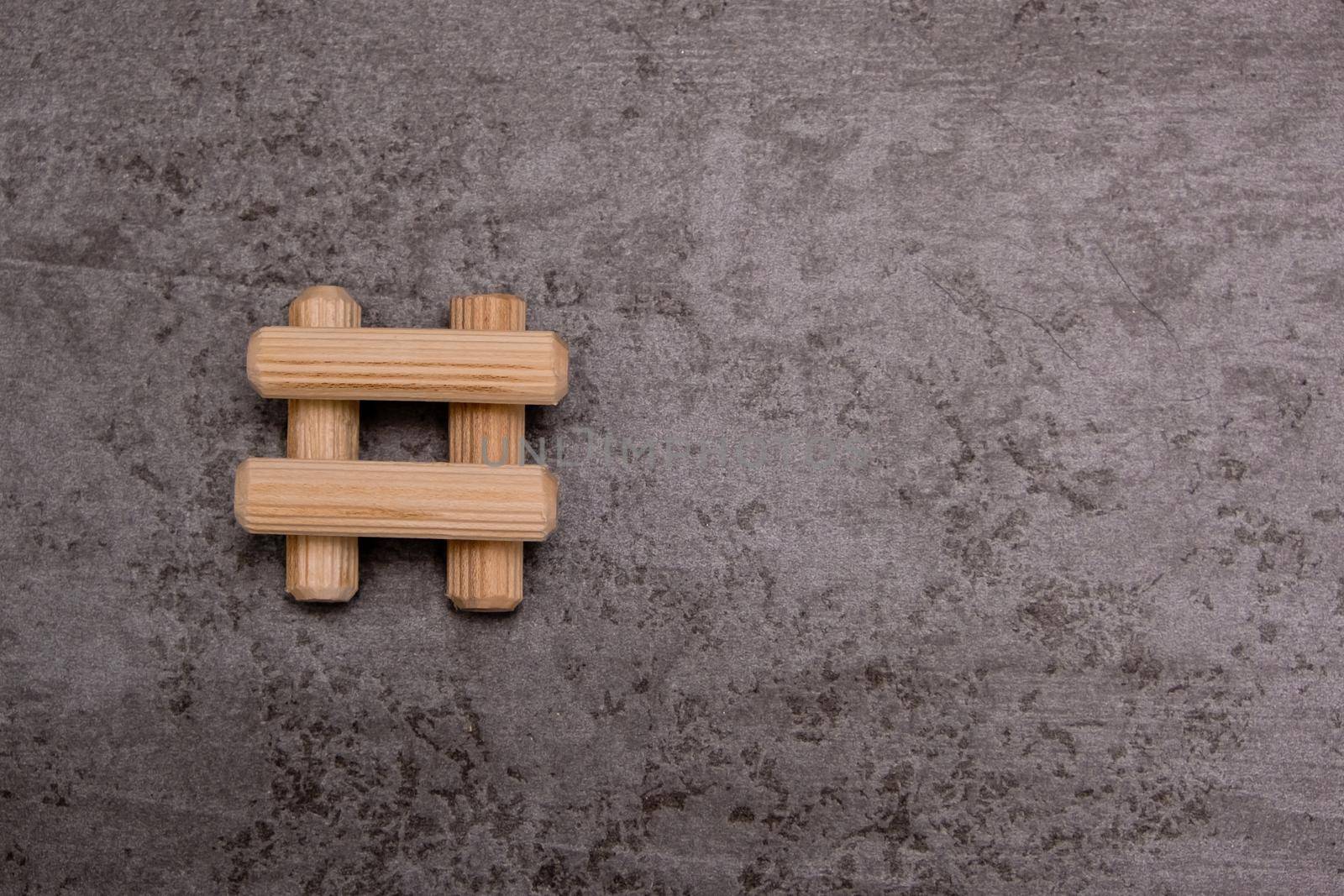 View of a grouping of wooden dowels on grey background. Close-up. Selective focus.