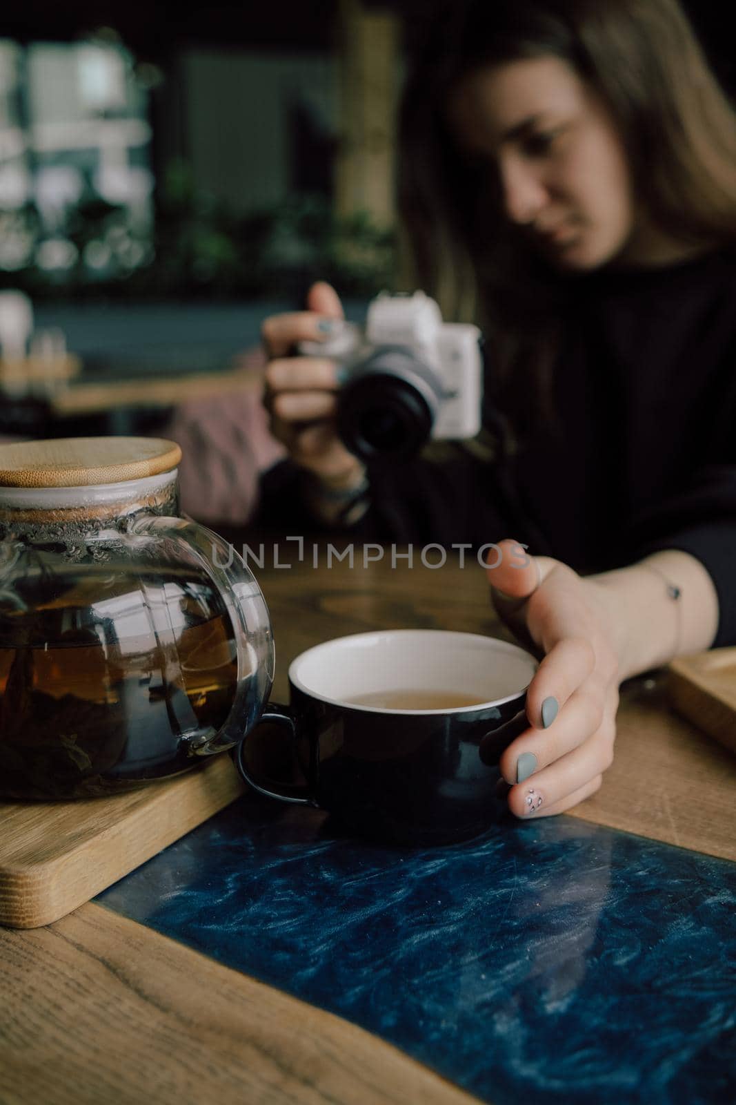 woman take photo of cup of tea. Selective focus on cup.