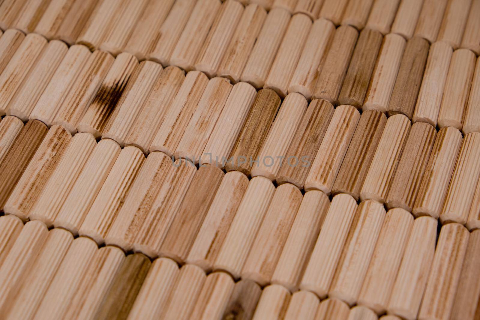 View of a grouping of wooden dowels as background. Close-up. Selective focus.