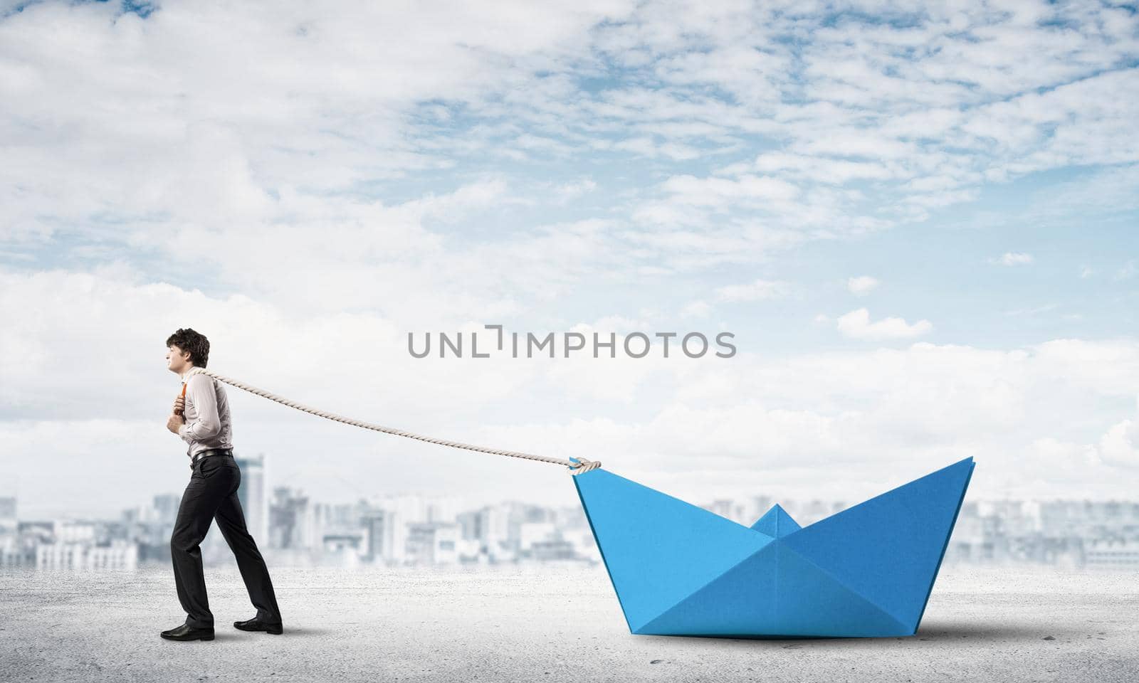 Successful businessman pulling with rope paper boat