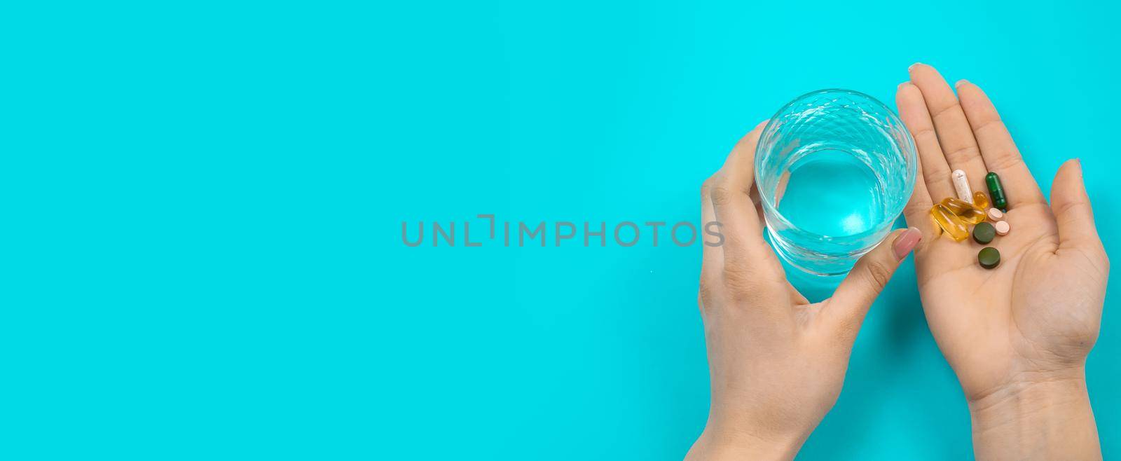 Omega 3 fish oil capsules spilling out of a bottle on a blue background.
