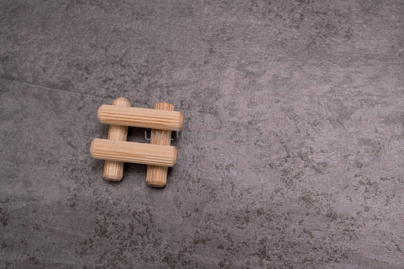 View of a grouping of wooden dowels on grey background. Close-up. Selective focus. by leonik