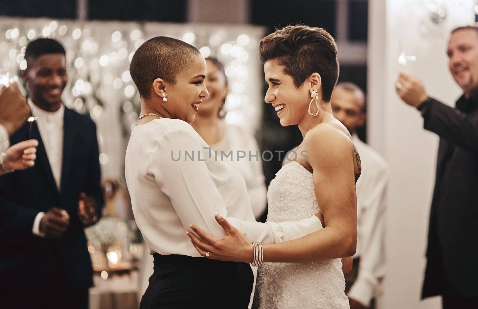 Can I have this dance, my love. Shot of a newlywed couple dancing while being surrounded by their guests. by YuriArcurs