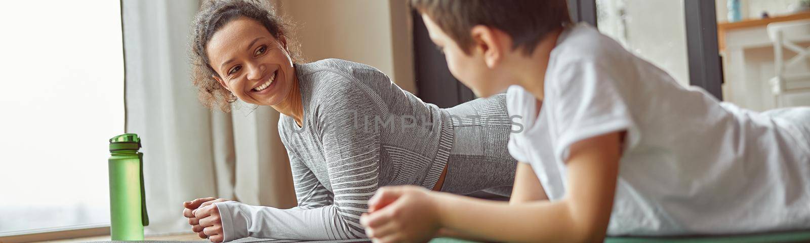 Cheerful mom enjoying workout with son indoors by Yaroslav_astakhov