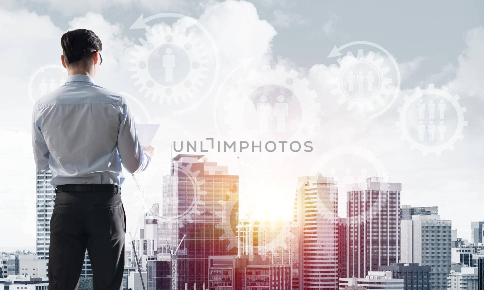 Young elegant businessman standing with back looking at business city