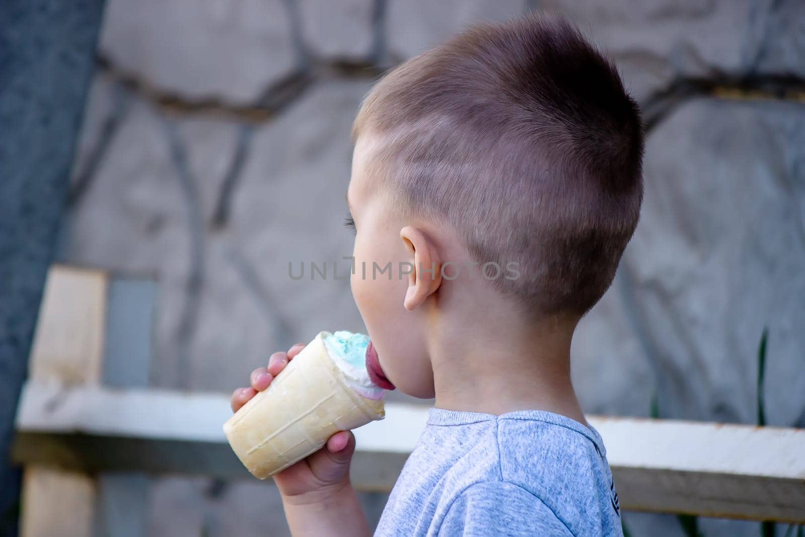 child eats ice cream in nature, ice cream in a cup. Selective focus by Anuta23