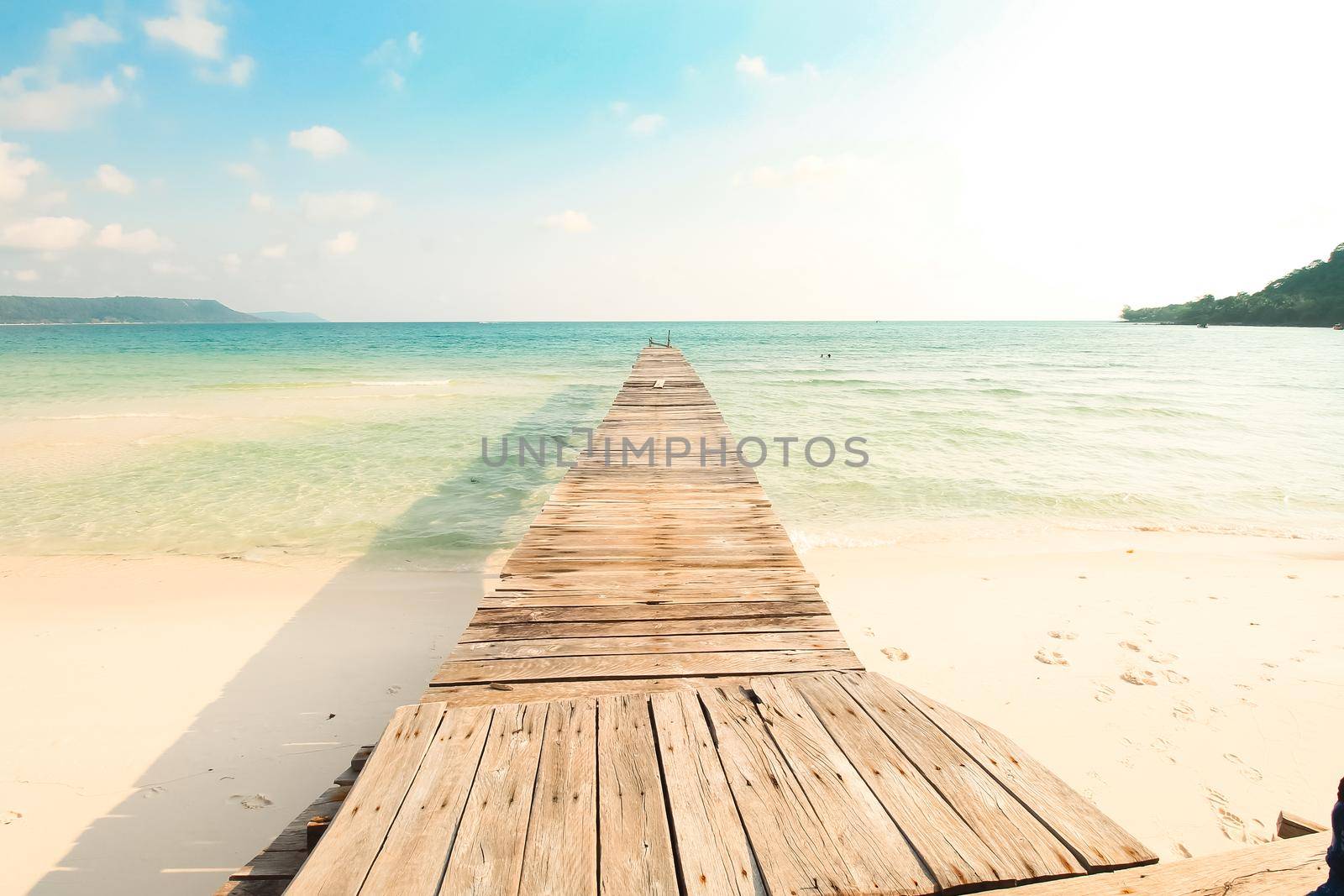 Wooden boardwalk leading to the white sandy beach of Koh Rong Samloen Island, a popular summer getaway destination in Cambodia