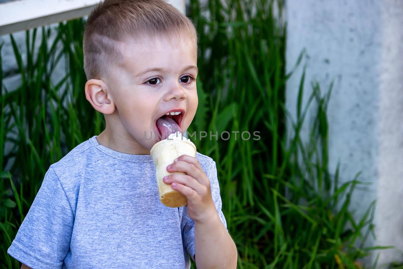 child eats ice cream in nature, ice cream in a cup. Selective focus by Anuta23