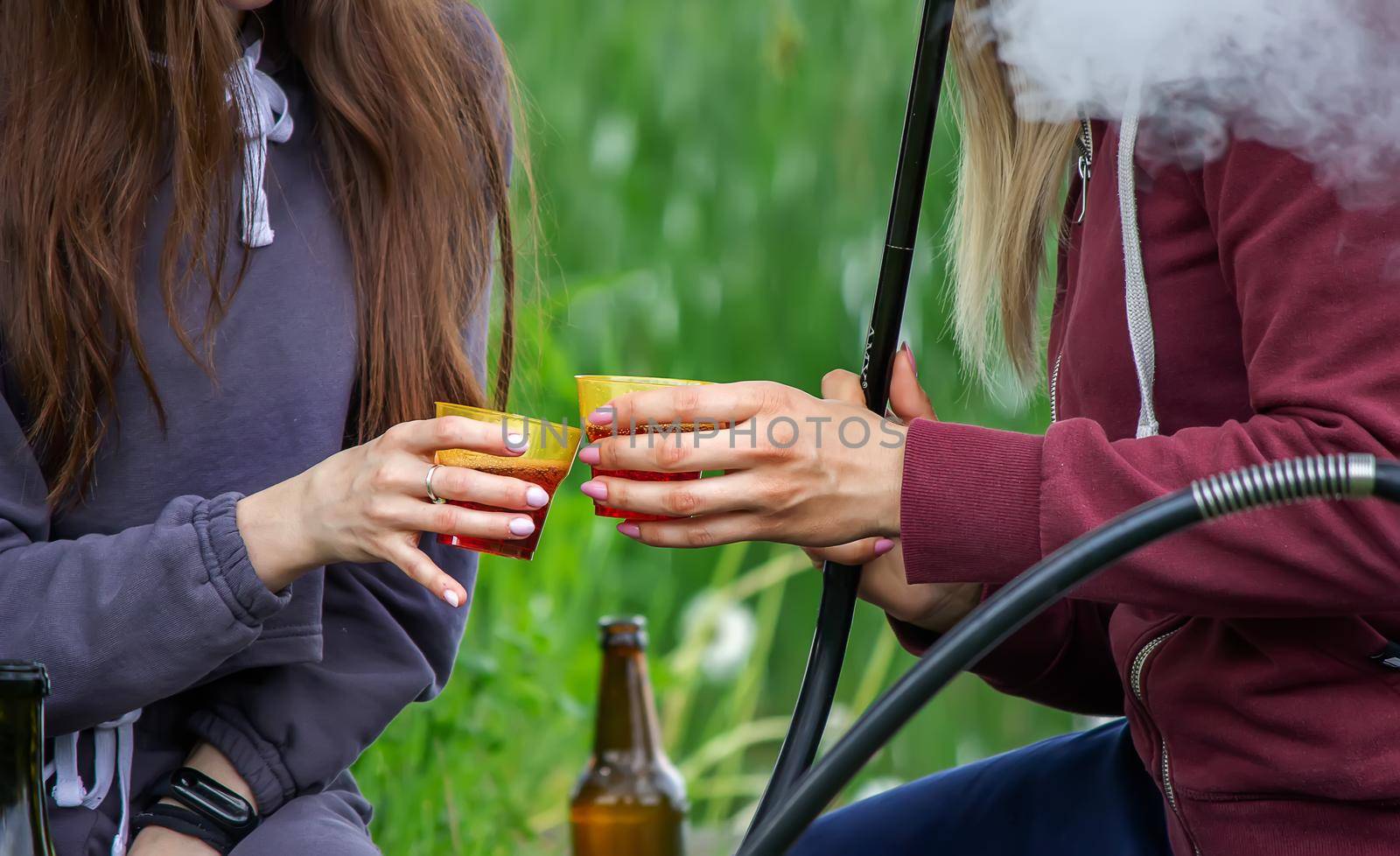 girls drink wine in nature by the river. Selective focus by Anuta23