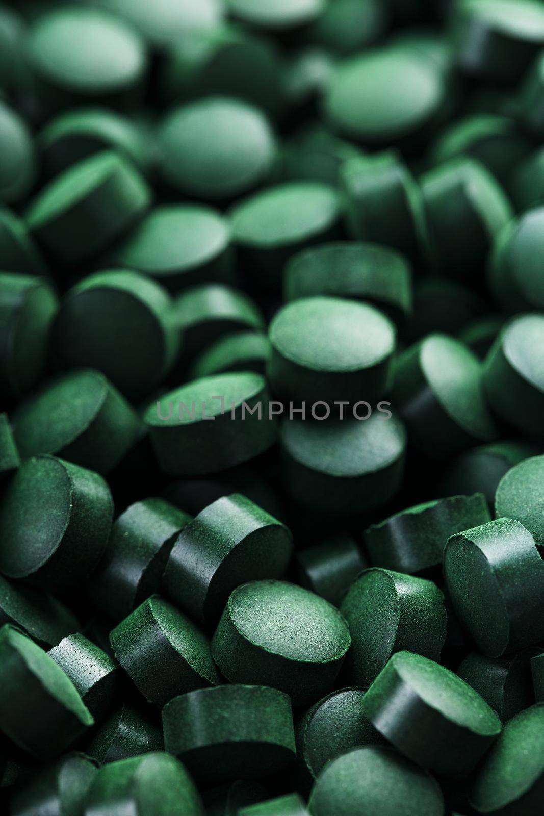 Green tablets from spirulina vegetarian dietary supplement as a full-screen texture