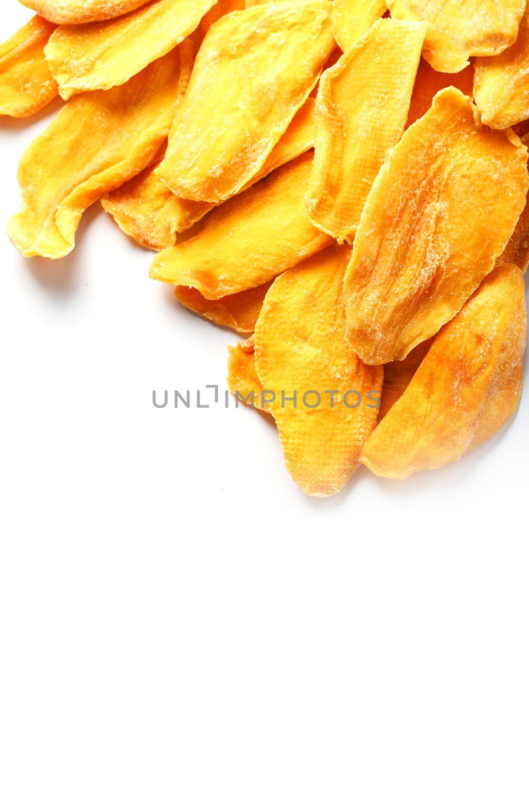 Dried mango sliced on a white background with free space by AlexGrec
