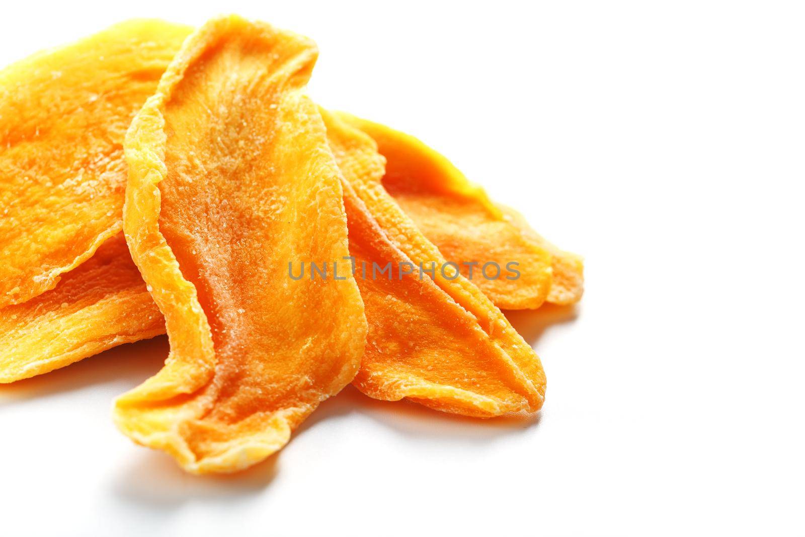 Dried sweet mango fruit slices as textural orange background in full screen