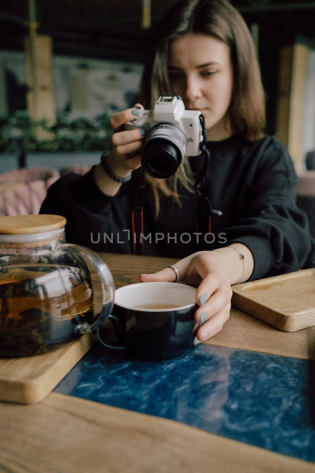 woman take photo of cup of tea. Selective focus on cup.