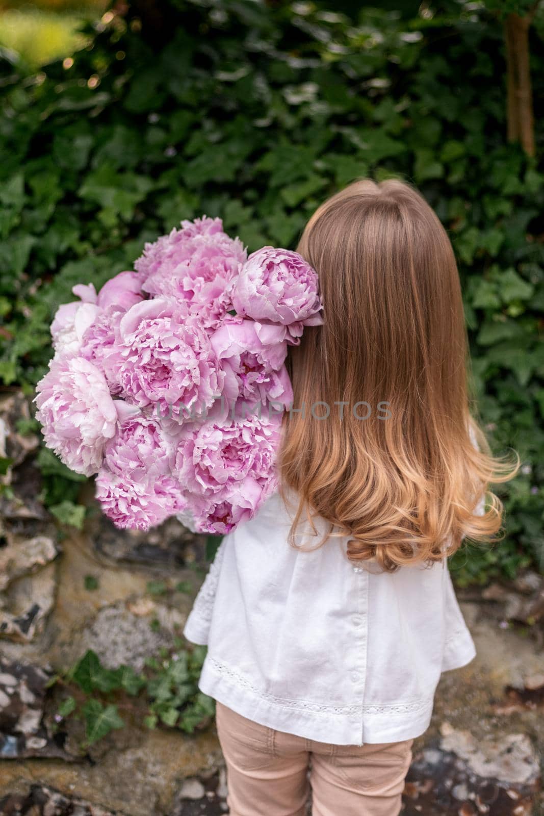 Girl holding fresh peonies bouquet