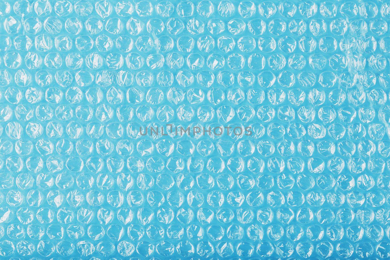 Packing bubble wrap for parcels on a blue background in full screen