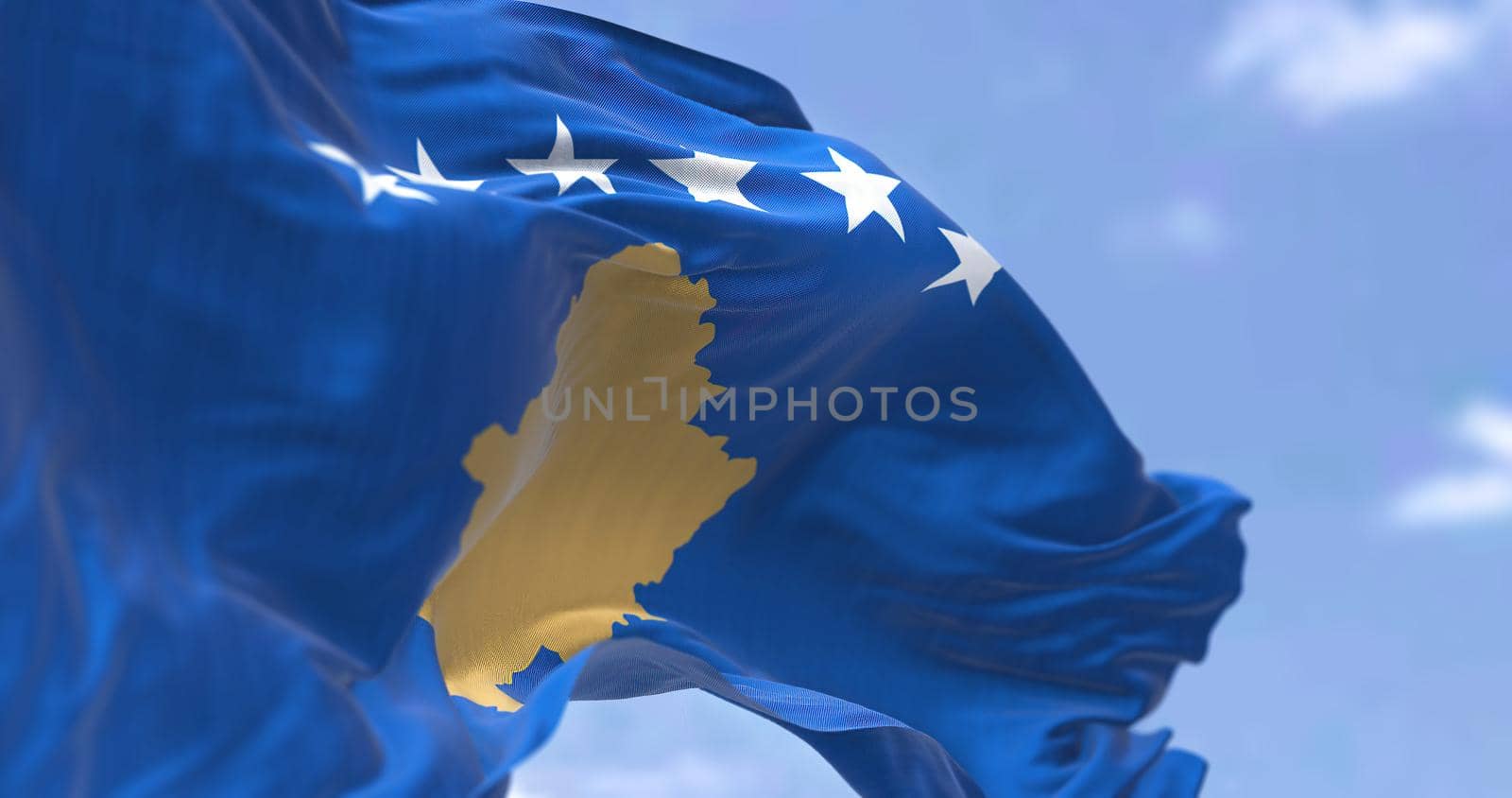 Detail of the national flag of Kosovo waving in the wind on a clear day by rarrarorro