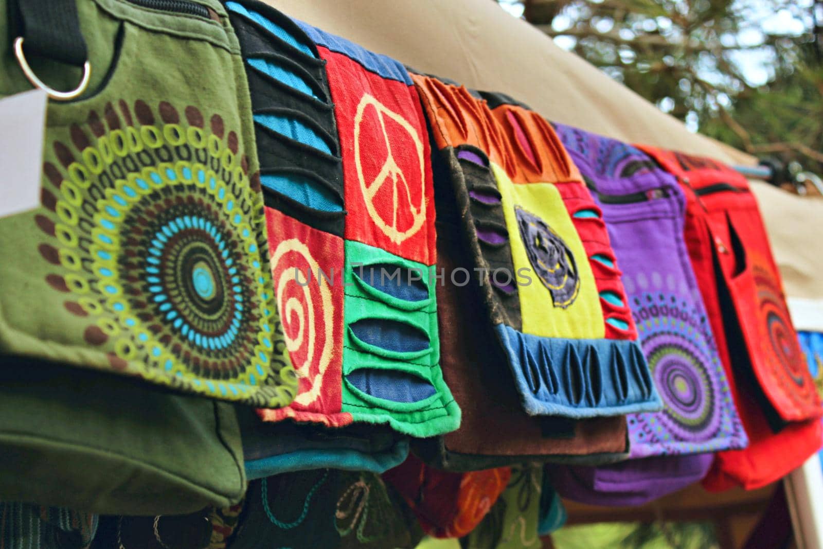 Bohemian bags made from natural materials at a clothes stand in a hippy festival market