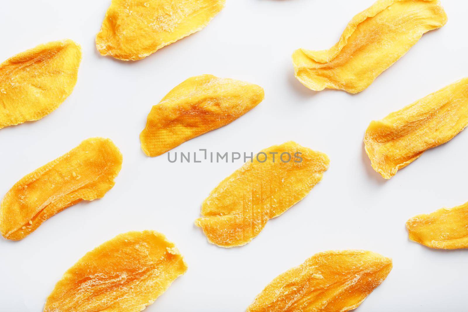 Organic dried mango fruit slices isolated on white background
