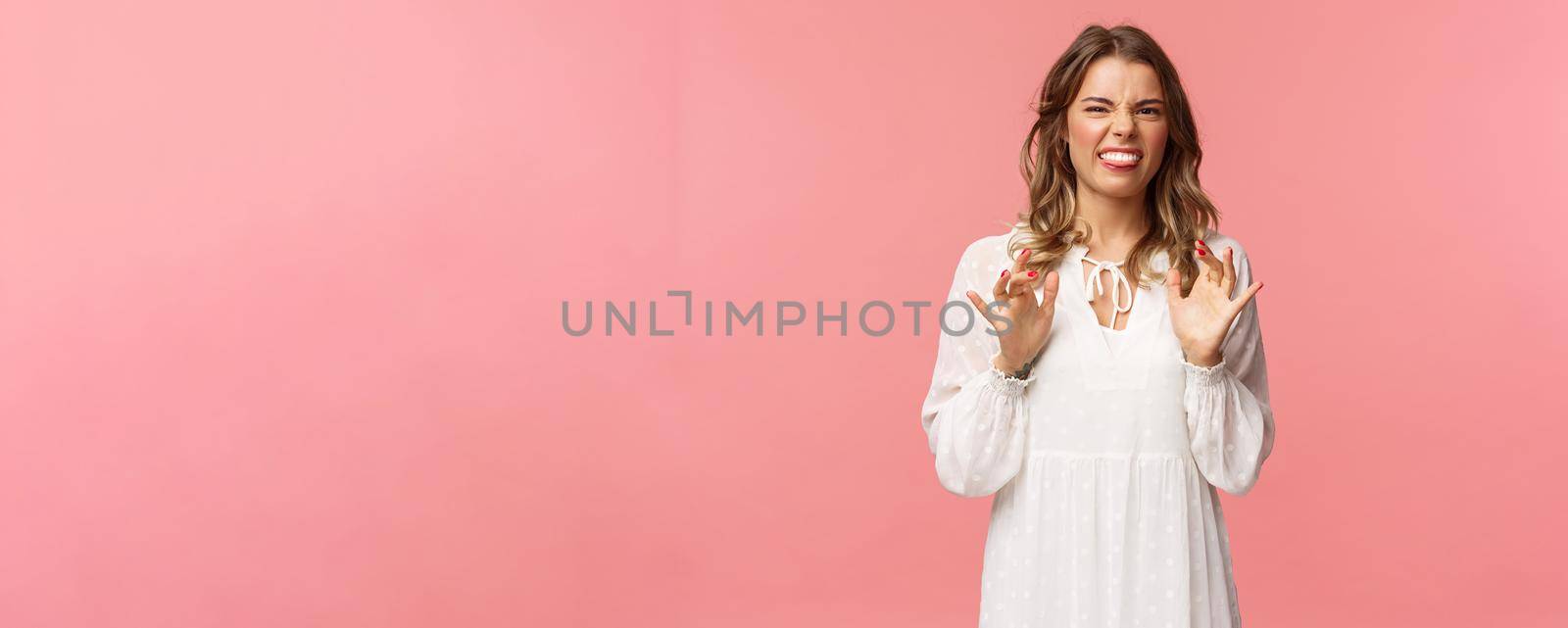 Portrait of girl cringe as telling friend disgusting awful story of her date with guy, show tongue grimacing and press hands to body as feeling discomfort and aversion, stand pink background.
