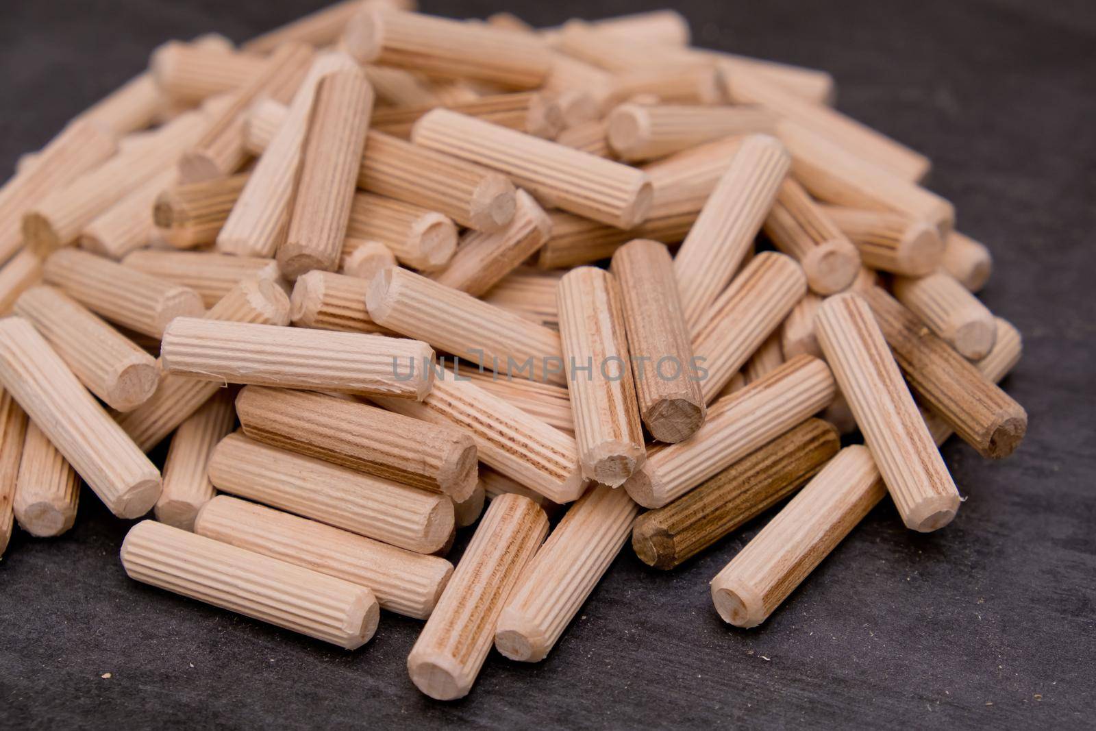View of a grouping of wooden dowels on grey background. Close-up. Selective focus. by leonik
