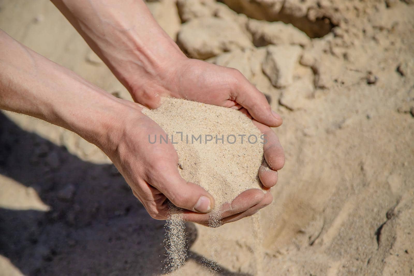 Man holding sand in his hands