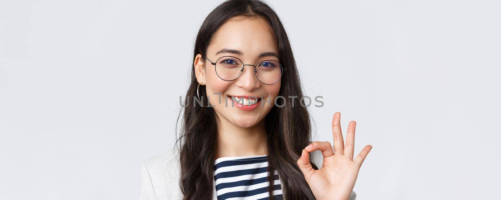 Business, finance and employment, female successful entrepreneurs concept. Close-up of cheerful office lady, asian bank clerk in glasses, smiling and showing okay gesture in approval.